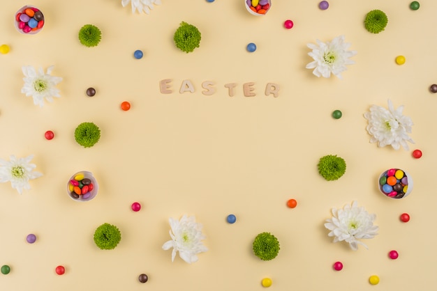 Inscription de Pâques avec des fleurs et des bonbons sur la table