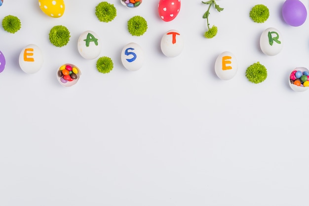 Inscription de Pâques sur des oeufs avec des fleurs sur la table