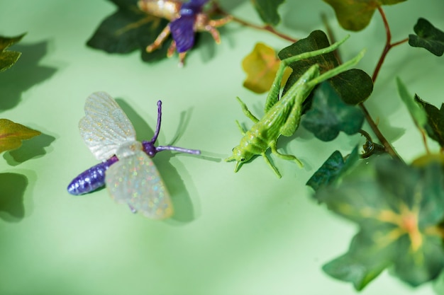 Insecte en plastique parmi les feuilles vertes