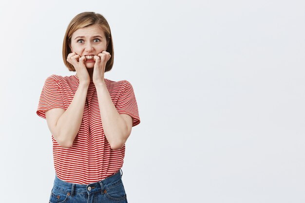 Insécurité et alarmé jeune femme se mordant l'ongle et se sentir inquiet