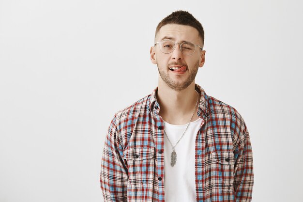 Insouciant beau jeune homme avec des lunettes posant