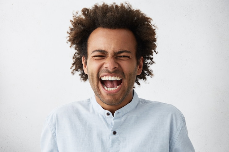 Photo gratuit insouciant joyeux bel homme afro-américain avec une coiffure touffue