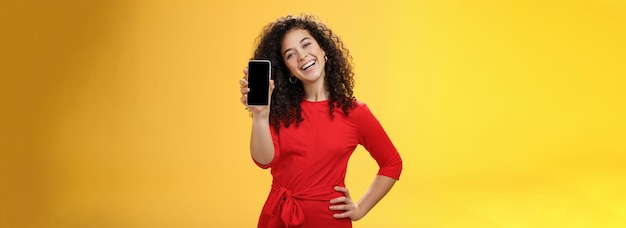 Insouciante satisfaite et heureuse femme d'affaires attrayante présentant son meilleur ami nouveau téléphone mobile sh
