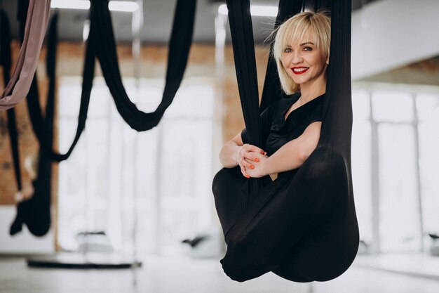 Instructeur féminin de yoga volant au gymnase