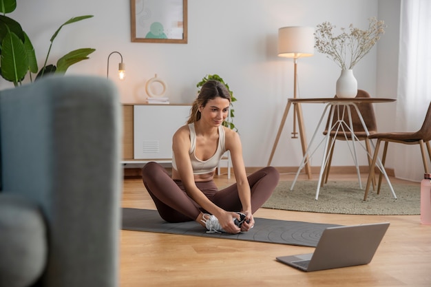 Instructeur de fitness féminin utilisant un ordinateur portable pour enseigner un cours à domicile