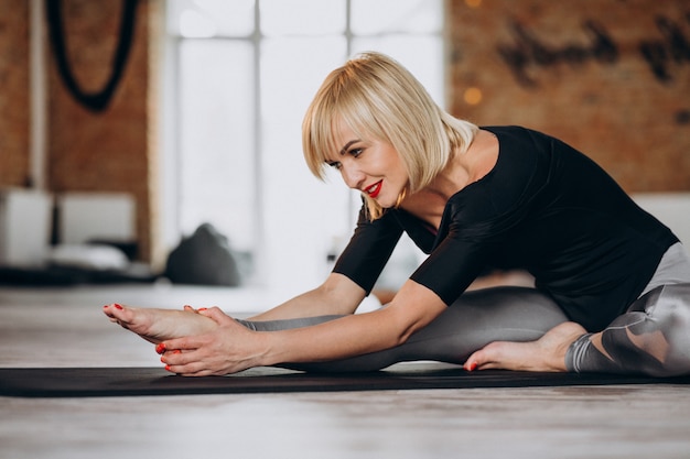 Instructeur de yoga féminin exerçant au gymnase