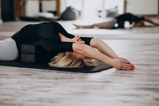 Instructeur de yoga féminin exerçant au gymnase