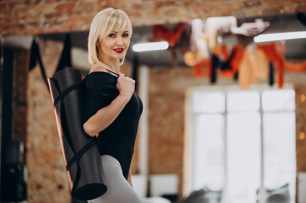 Instructeur de yoga féminin exerçant au gymnase