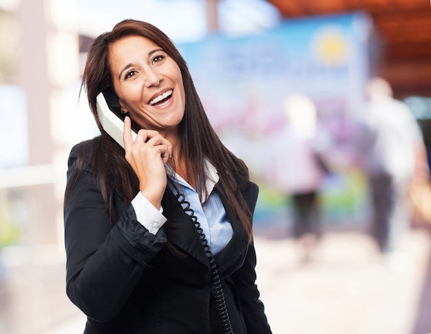 Intelligente femme en riant tout en parlant au téléphone