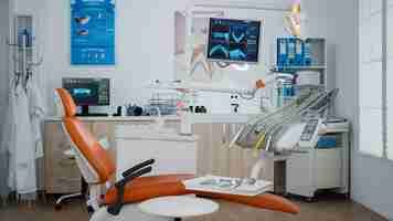 Photo gratuite intérieur du cabinet dentaire équipé moderne avec rayons x sur moniteurs, lieu de travail orthodontique de stomatologie dentiste