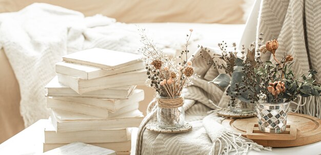 Intérieur de la maison avec des livres et des fleurs séchées.