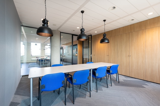 Photo gratuite intérieur de la salle de réunion d'un bureau moderne avec une longue table en bois et des chaises autour d'elle