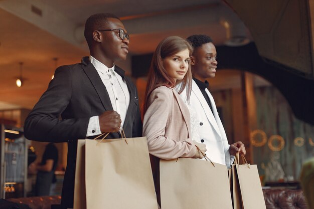 Internationals personnes debout dans un café avec des sacs à provisions