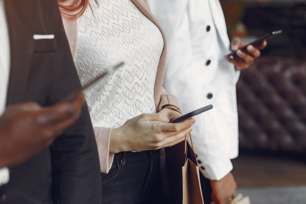 Internationals personnes debout dans un café avec des sacs à provisions