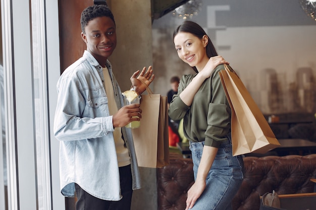 Internationals personnes debout dans un café avec des sacs à provisions