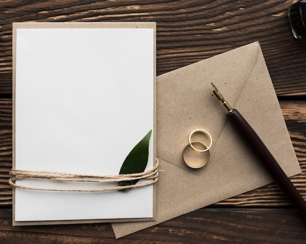 Invitation de mariage sur table avec bagues de fiançailles