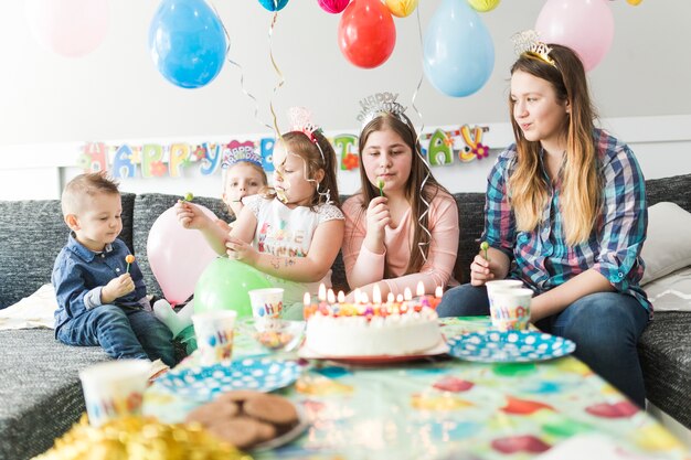 Invités à l&#39;anniversaire arty près de gâteau