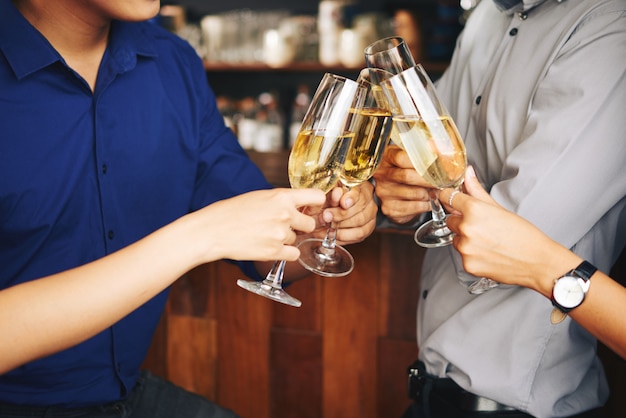 Invités fêtards méconnaissables applaudissant avec du champagne au bar