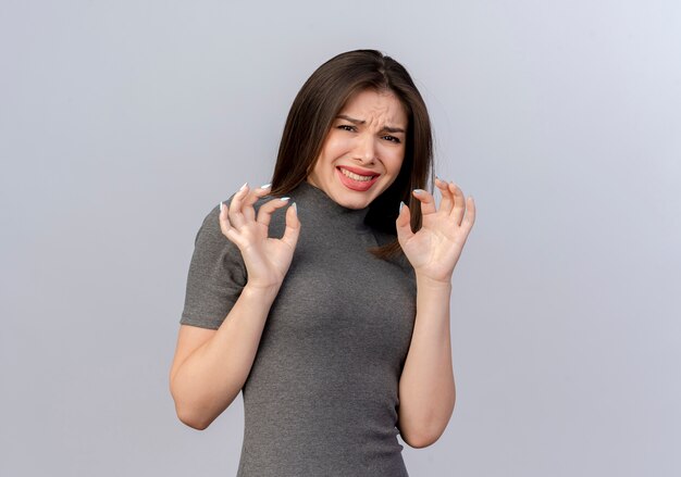 Irritée jeune jolie femme gardant les mains en l'air isolé sur fond blanc avec copie espace