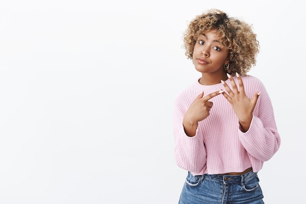 J'attends la proposition. Femme afro-américaine irritée et affirmée aux cheveux blonds boudant et regardant la caméra interrogée levant la main et pointant du doigt demandant une bague voulant se marier