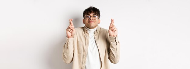 J'espère qu'un jeune homme heureux fait un vœu et sourit à la caméra pleine d'espoir en attendant que le rêve devienne réalité