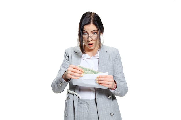 J'espère que ce n'est qu'une blague. Jeune femme en costume gris obtenant un petit salaire et n'en croyant pas ses yeux. Choqué et indigné. Concept des problèmes, des affaires, des problèmes et du stress de l'employé de bureau.