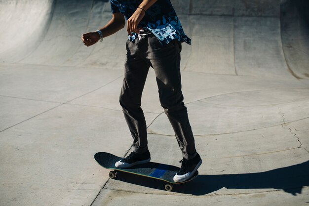 Les jambes du jeune homme avec une planche à roulettes