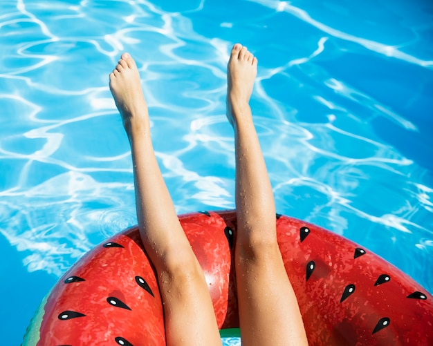 Jambes à l'envers avec floatie melon d'eau