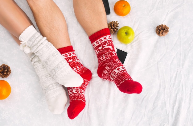 Jambes féminines et masculines du couple dans des chaussettes de laine chaudes. Éléments d'hiver