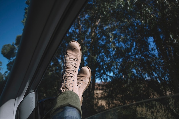 Jambes qui pendent de la fenêtre de la voiture