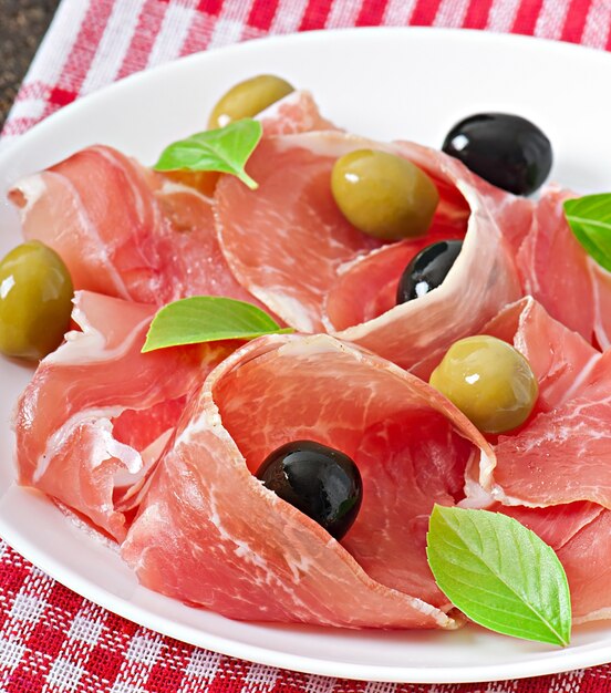 Jambon, olives, basilic sur vieux bois