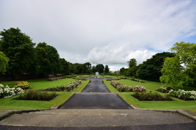 Jardin du château de Kilkenny entouré de verdure sous un ciel nuageux en Irlande