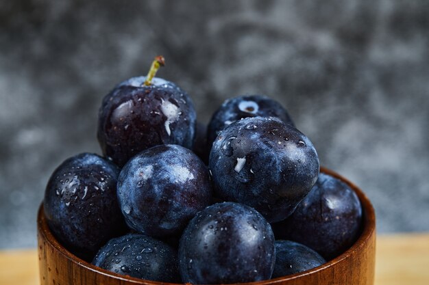 Jardin des prunes dans un bol à l'obscurité.