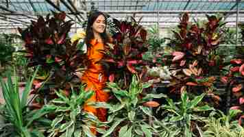 Photo gratuite jardinier femelle pulvériser de l'eau sur les plantes