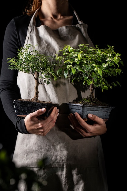 Jardinier vue de face tenant des plantes en pot