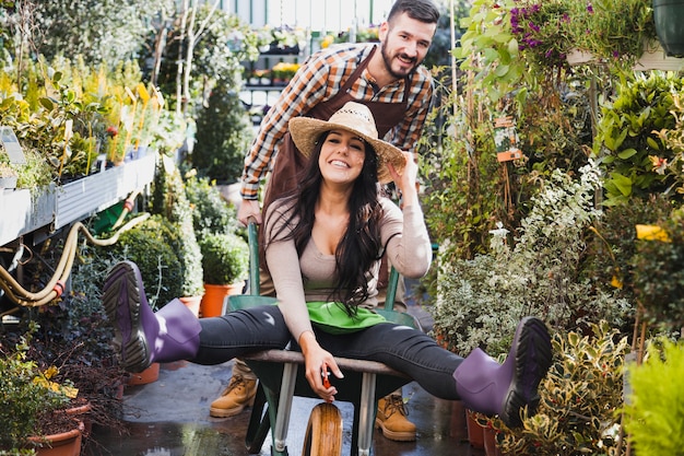 Photo gratuite les jardiniers s'amusent avec la brouette