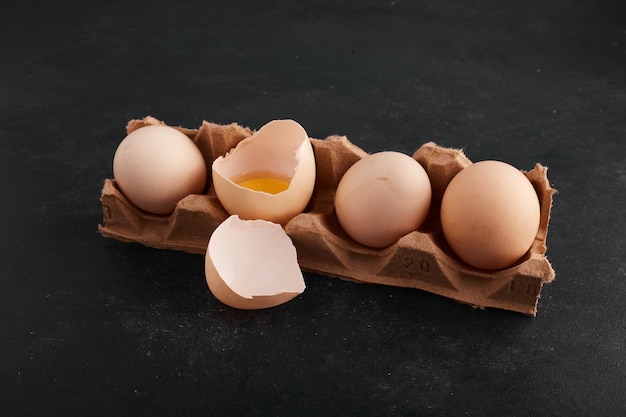 Jaune d'oeuf à l'intérieur de la coquille d'oeuf dans le plateau en carton.