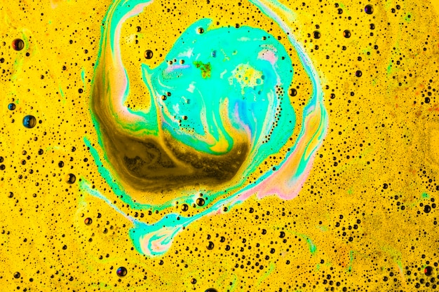 Jaune et turquoise dissolvent une bombe de bain dans l&#39;eau