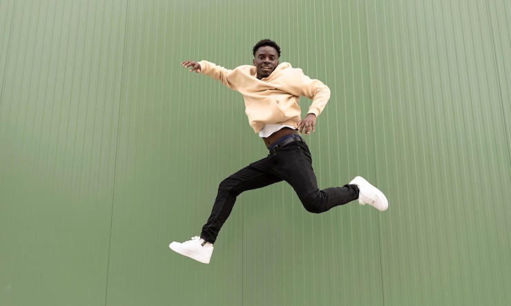 Photo gratuit je suis un adolescent qui saute en souriant.