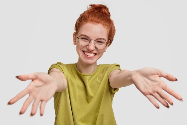 Photo gratuite je vais te faire un câlin! fille gaie rousse tire les mains à huis clos