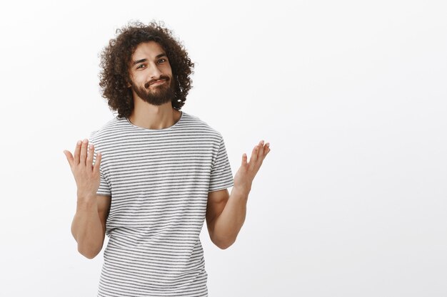 Je vous ai dit que j'avais raison. Beau modèle masculin oriental avec barbe et cheveux bouclés, levant les mains et souriant, étant soulagé et disant enfin