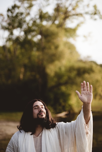 Photo gratuite jésus-christ avec sa main vers le ciel tandis que ses yeux sont fermés