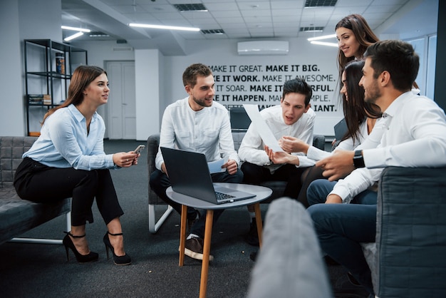 Jetez un œil à ce document. Travailler ensemble dans une atmosphère conviviale à l'aide d'un ordinateur portable sur la table