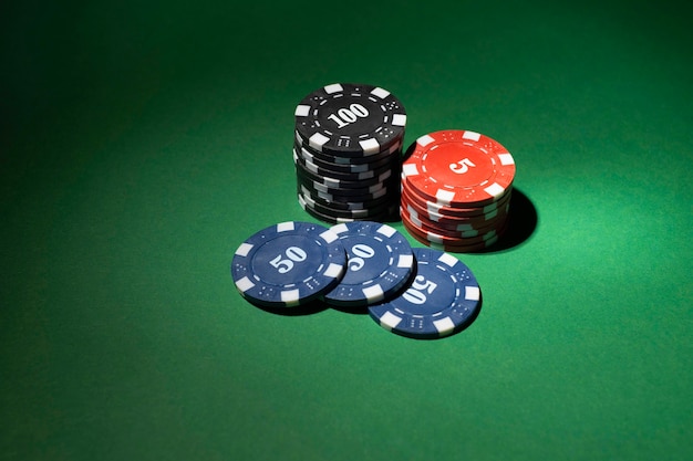 Photo gratuite jetons de casino empilés sur fond vert