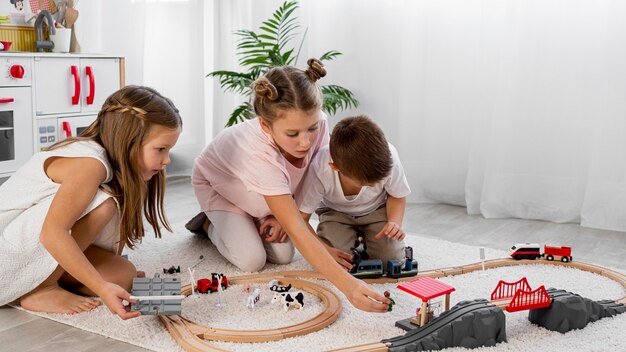 Jeu d'enfants non binaires jouant avec des voitures