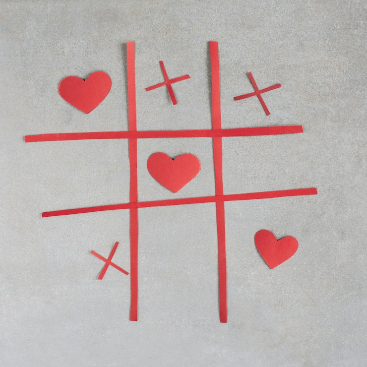 Photo gratuit jeu de tic tac toe avec coeurs d&#39;ornement rouges