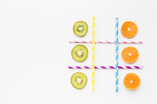 Photo gratuite jeu de ttic-tac-toe avec fruits et pailles