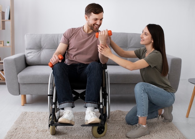 Photo gratuite jeune adulte aidant un ami handicapé