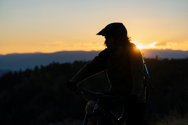 Jeune adulte à l'aide de vélo électrique à la campagne