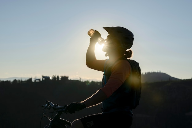 Jeune adulte à l'aide de vélo électrique à la campagne